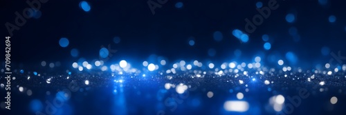 Blue bokeh lights background banner. Abstract blue backdrop with lights. Blue background with particles.