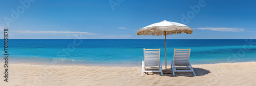 A paradisiacal beach and two sun loungers under an umbrella, the ideal destination for a holiday