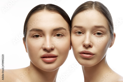 Close up portrait of two well maintained girls, young women, friends with natural make-up looking at camera against white background. Concept of youth, skin care, cosmetic products, wellness.