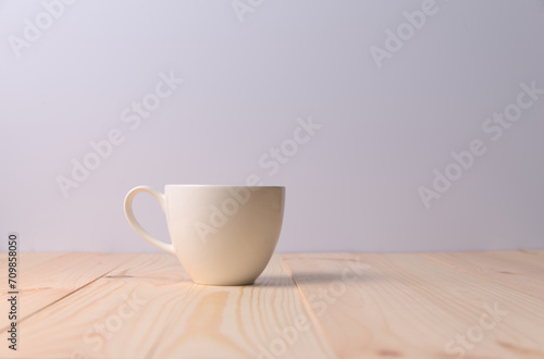 Hot drinks in a white cup on wooden table with white background.