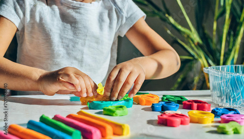 A little girl play with plasticine and creates colorful numbers. Learning to count through play. Early education. Fine motor skills, creativity and hobby