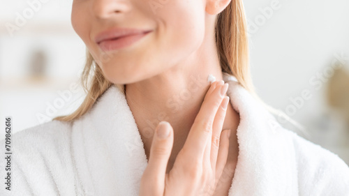 Cropped of lady pampering neck skin with moisturizer in bathroom