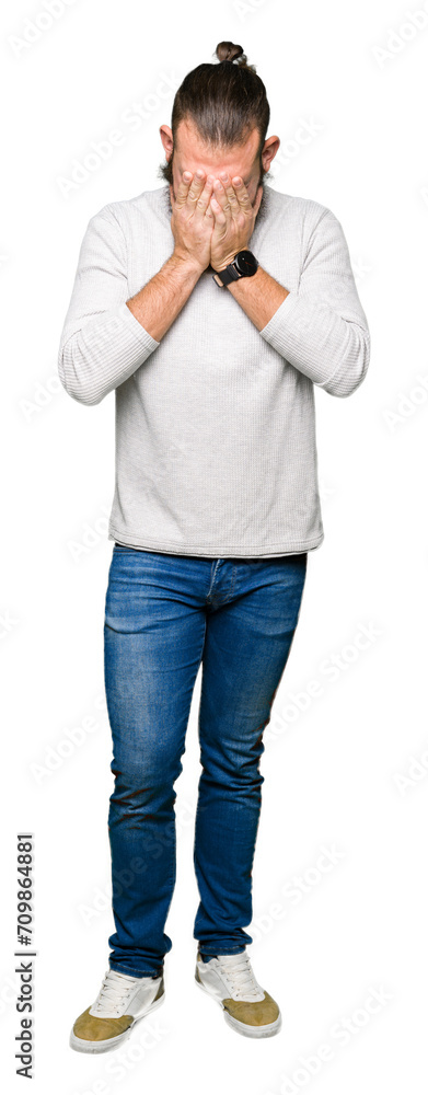 Young blond man wearing casual sweater with sad expression covering face with hands while crying. Depression concept. Young blond man wearing casual sweater with sad expression covering face with hands while crying. Depression concept.