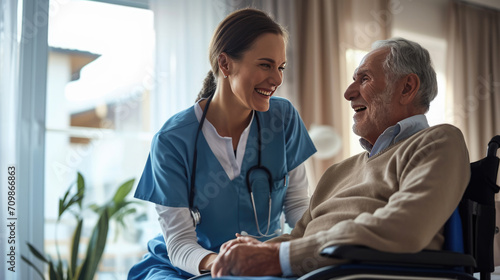Caring female nurse in blue scrubs smiling and holding hands with an elderly male patient
