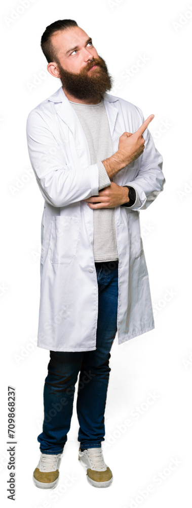 Young blond scientist man wearing white coat with a big smile on face, pointing with hand and finger to the side looking at the camera. Young blond scientist man wearing white coat with a big smile on face, pointing with hand and finger to the side looking at the camera.