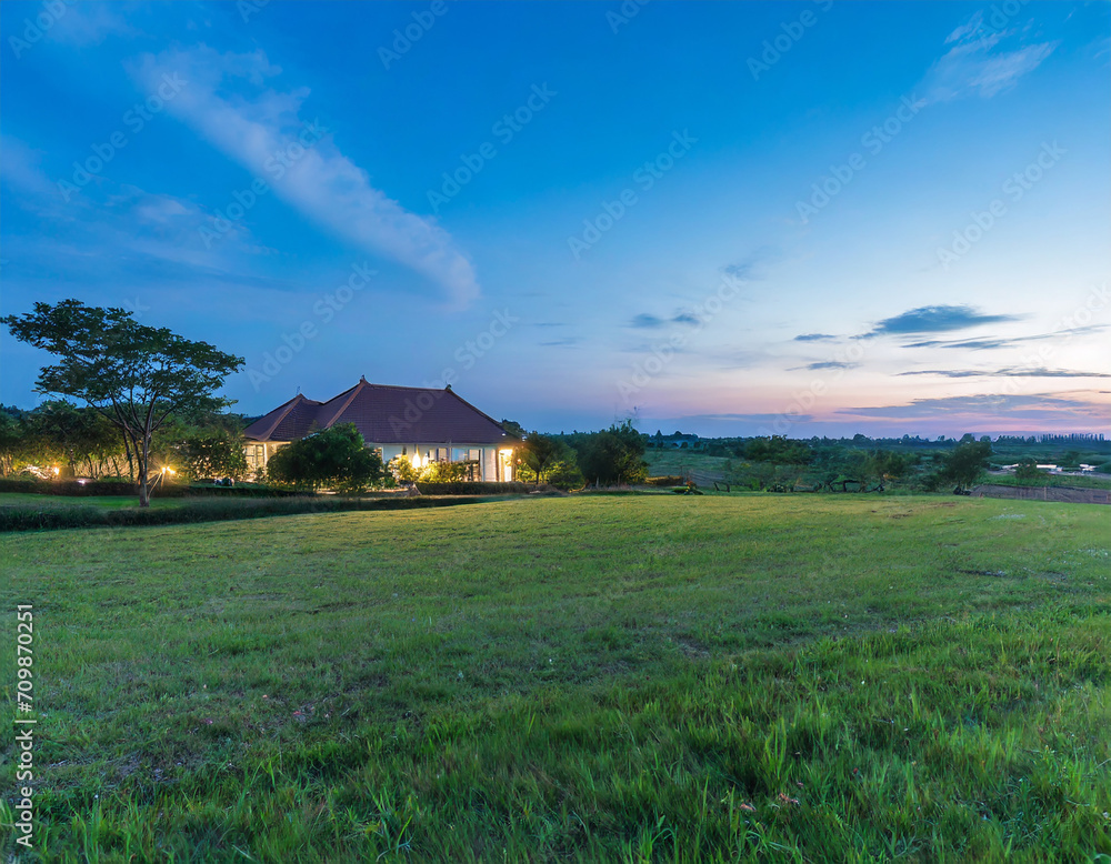 beautiful meadow with clear sky and countryside house at dusk beautiful meadow with clear sky and countryside house at dusk