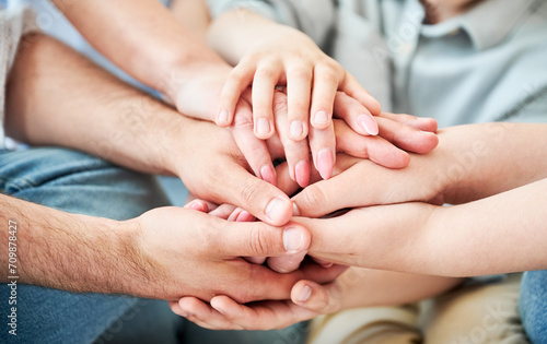 Close-up of several hands placed on top of one another in stack. All family members showing their support to each other. Concept of togetherness, unity, teamwork, family, solidarity, mutual support. © anatoliy_gleb