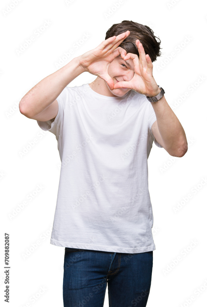 Young handsome man wearing casual white t-shirt over isolated background Doing heart shape with hand and fingers smiling looking through sign Young handsome man wearing casual white t-shirt over isolated background Doing heart shape with hand and fingers smiling looking through sign