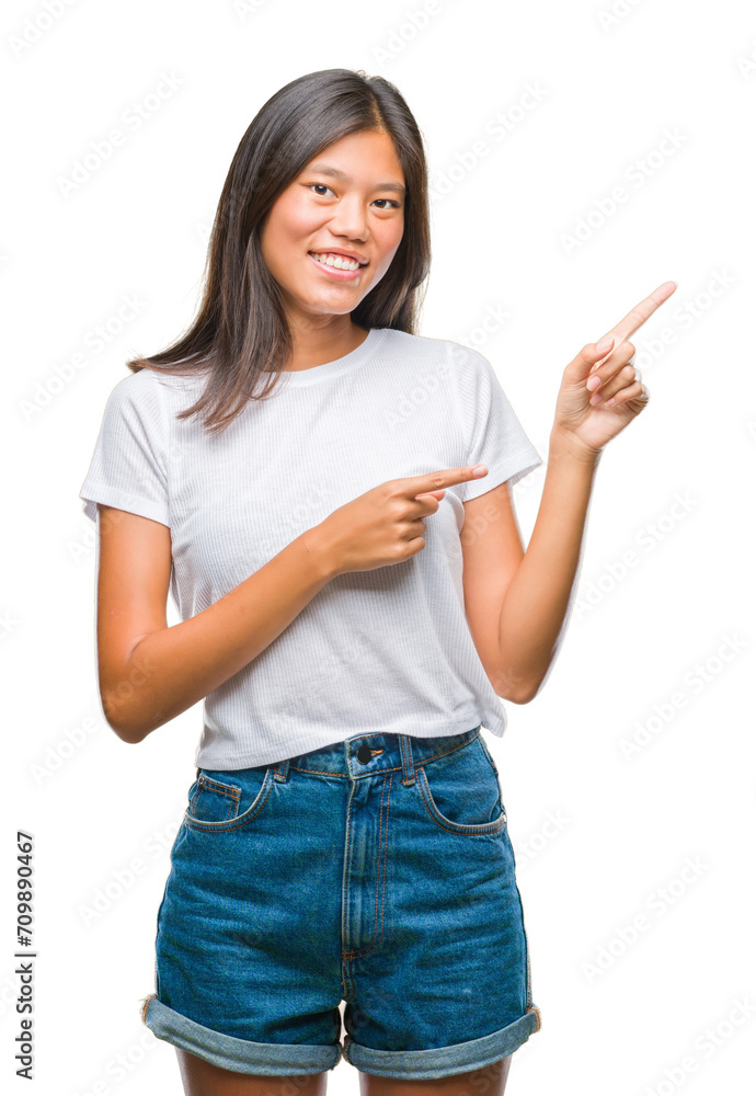 Young asian woman over isolated background smiling and looking at the camera pointing with two hands and fingers to the side. Young asian woman over isolated background smiling and looking at the camera pointing with two hands and fingers to the side.