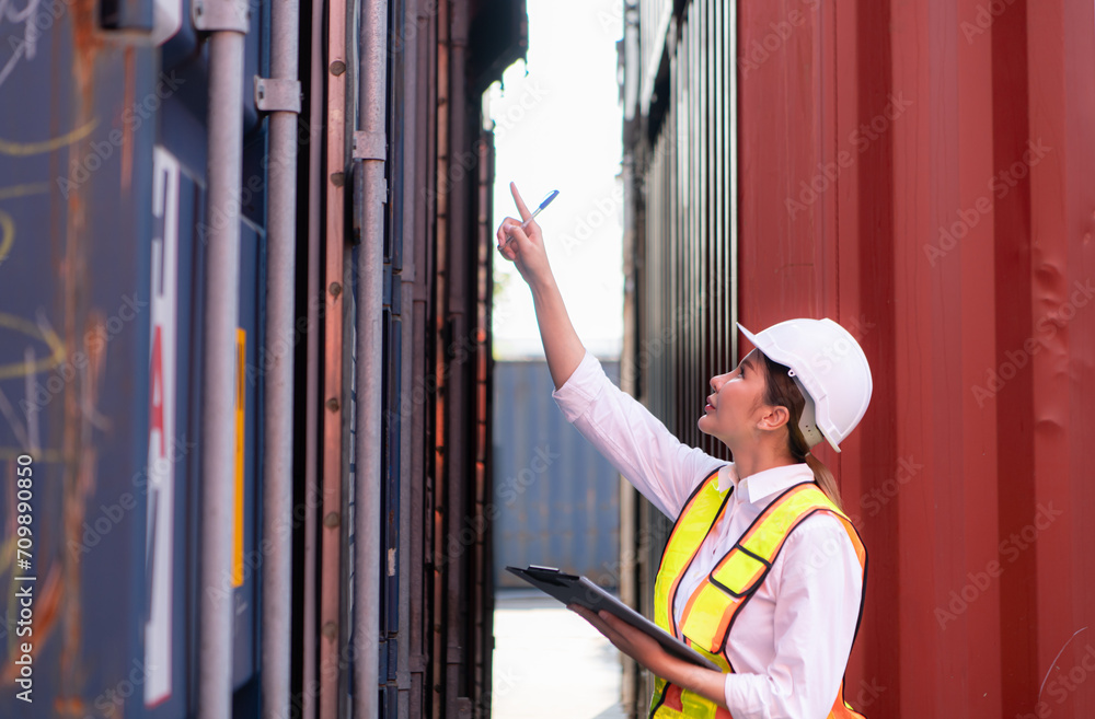 Workers in the import and export industries inspect the cargo of containers while holding a laptop and standing between them. Workers in the import and export industries inspect the cargo of containers while holding a laptop and standing between them.