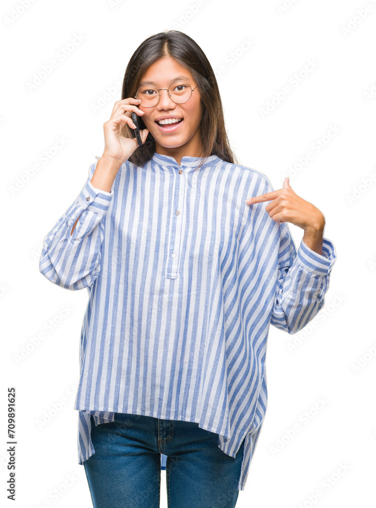 Young asian woman speaking on the phone over isolated background with surprise face pointing finger to himself Young asian woman speaking on the phone over isolated background with surprise face pointing finger to himself