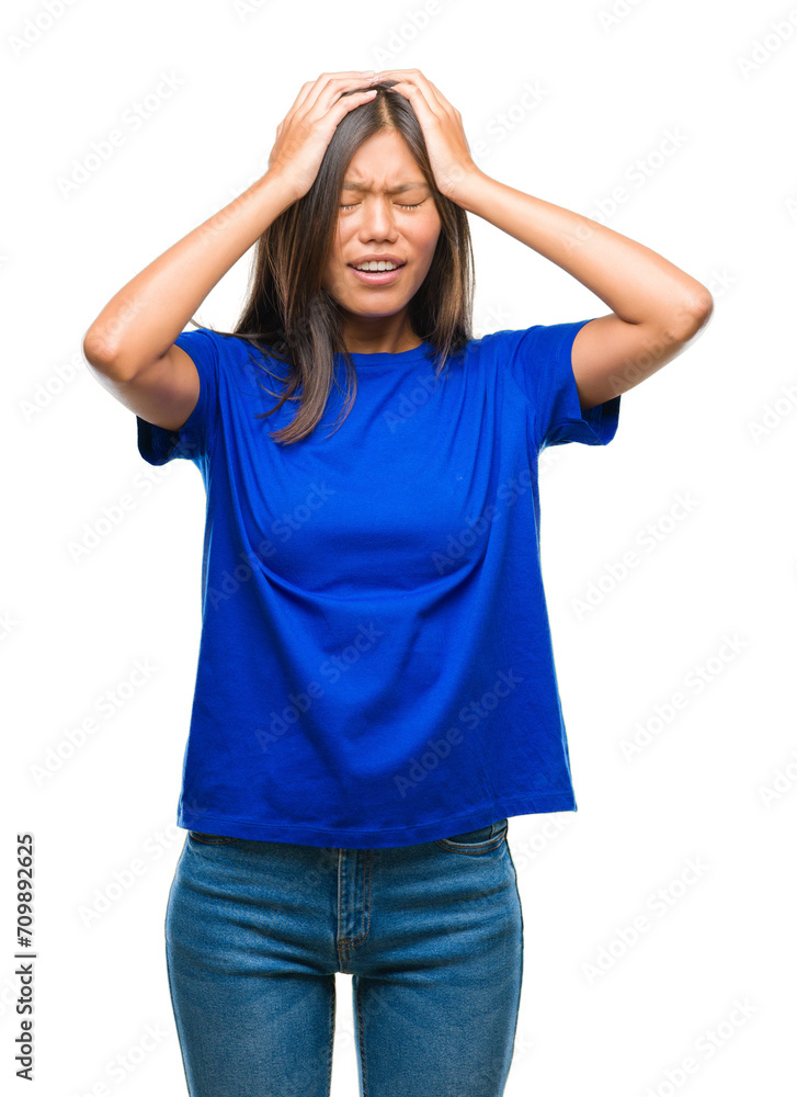 Young asian woman over isolated background suffering from headache desperate and stressed because pain and migraine. Hands on head. Young asian woman over isolated background suffering from headache desperate and stressed because pain and migraine. Hands on head.
