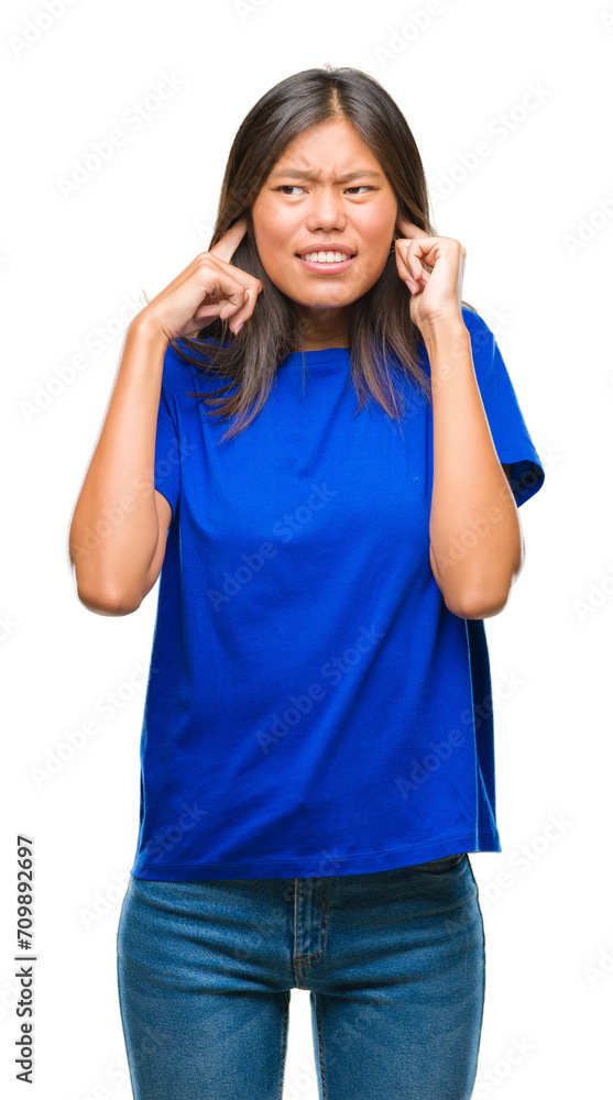 Young asian woman over isolated background covering ears with fingers with annoyed expression for the noise of loud music. Deaf concept. Young asian woman over isolated background covering ears with fingers with annoyed expression for the noise of loud music. Deaf concept.