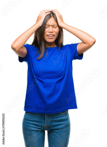 Young asian woman over isolated background suffering from headache desperate and stressed because pain and migraine. Hands on head. © Krakenimages.com