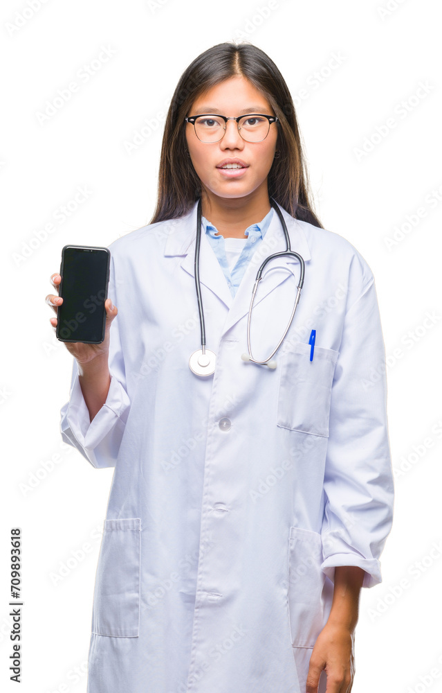 Young asian doctor woman holding smartphone over isolated background with a confident expression on smart face thinking serious