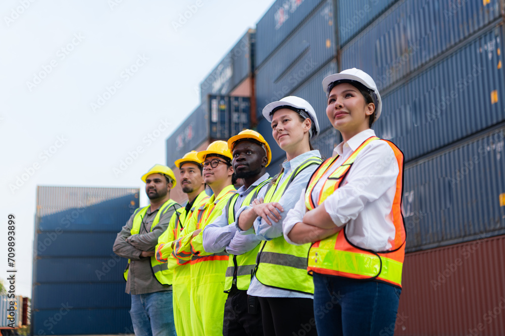 Group of worker wearing safety helmet and reflective vest standing in front of containers. Group of worker wearing safety helmet and reflective vest standing in front of containers.