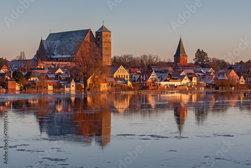 Verden an der Aller in Niedersachsen, Deutschland mit dem Dom bei starkem Hochwasser. Die Gebäude spiegeln im Wasser mit Eisschollen.  photo