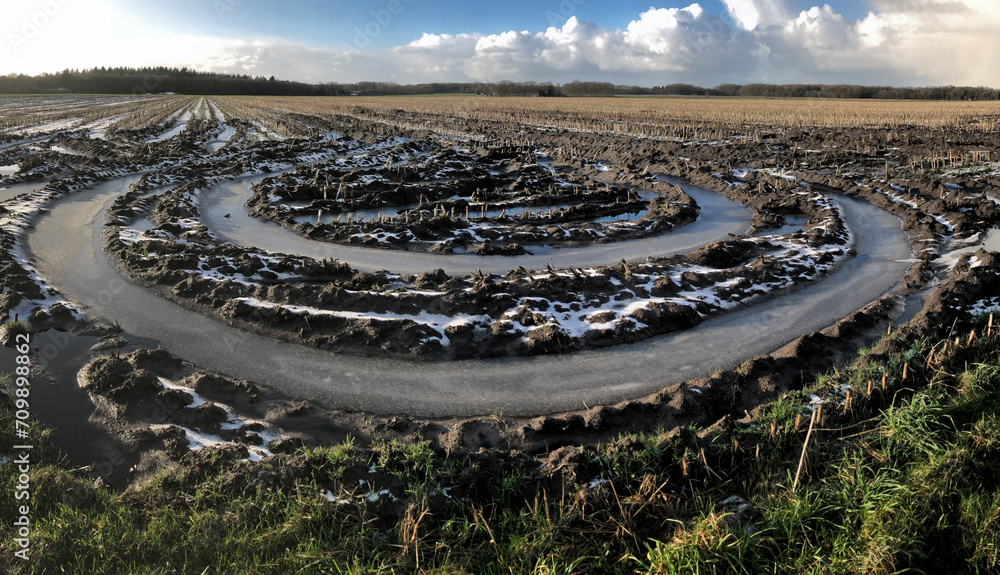 Winter at the es of Uffelte Drenthe Netherlands. Fields with frozen water. Ice. Circles in the muddy field. Panorama. Country life. Circles in the landscape. Mud tracks.