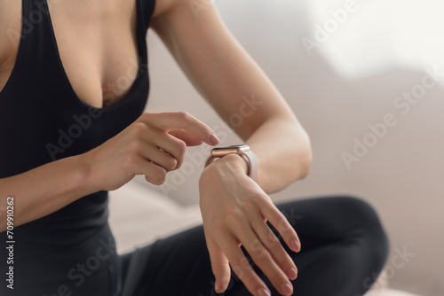 Young fit athletic woman checking progress on smart watch