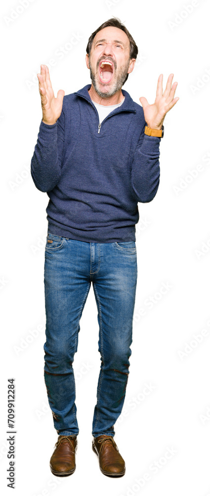 Middle age handsome man wearing a sweater crazy and mad shouting and yelling with aggressive expression and arms raised. Frustration concept. Middle age handsome man wearing a sweater crazy and mad shouting and yelling with aggressive expression and arms raised. Frustration concept.