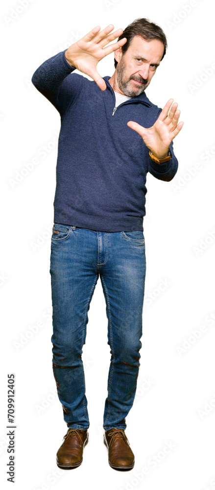 Middle age handsome man wearing a sweater Smiling doing frame using hands palms and fingers, camera perspective Middle age handsome man wearing a sweater Smiling doing frame using hands palms and fingers, camera perspective