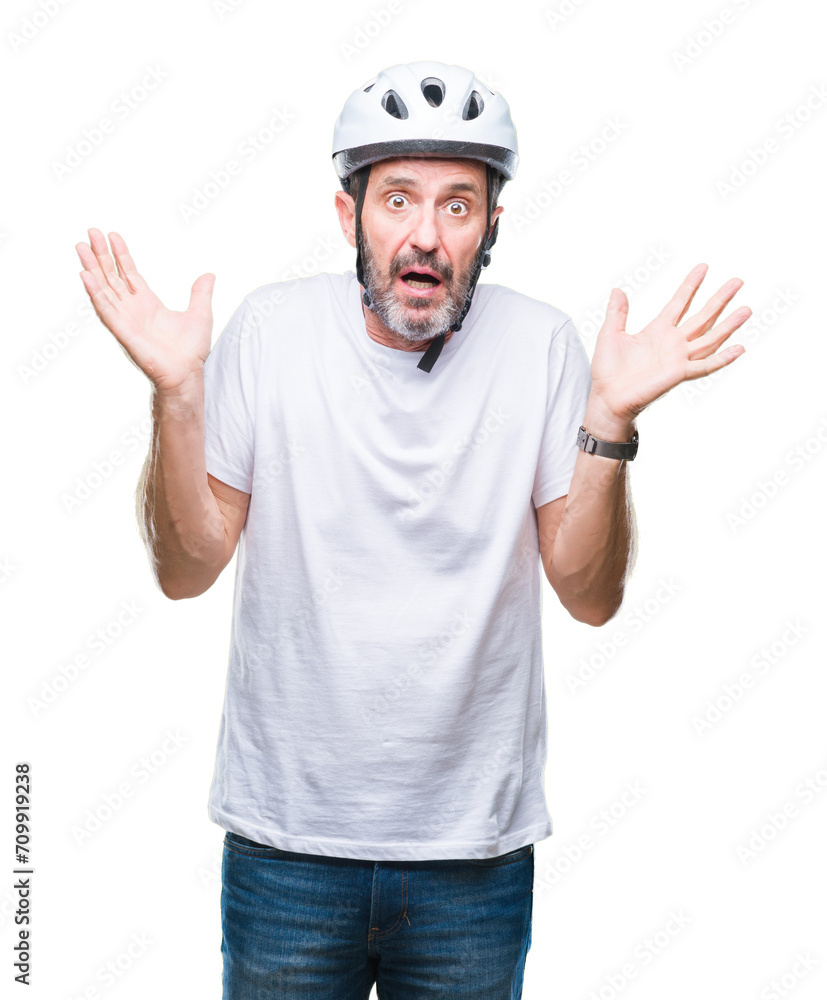 Middle age senior hoary cyclist man wearing bike safety helment isolated background clueless and confused expression with arms and hands raised. Doubt concept. Middle age senior hoary cyclist man wearing bike safety helment isolated background clueless and confused expression with arms and hands raised. Doubt concept.