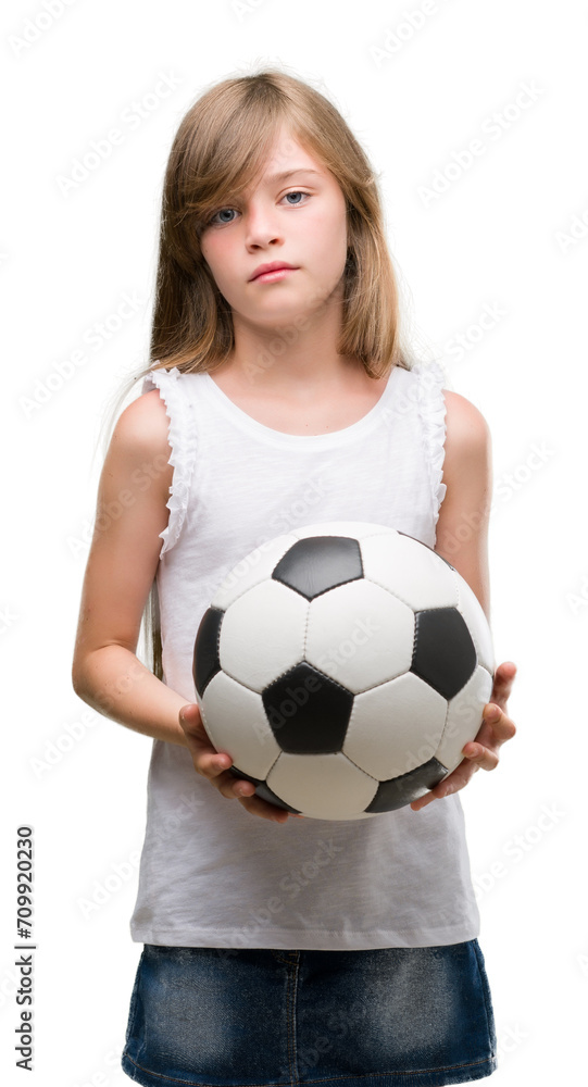 Young blonde toddler holding football ball with a confident expression on smart face thinking serious