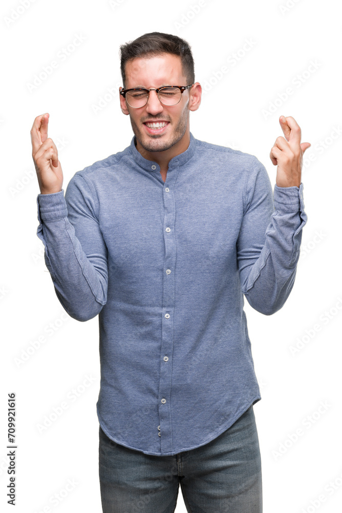 Handsome young elegant man wearing glasses smiling crossing fingers with hope and eyes closed. Luck and superstitious concept. Handsome young elegant man wearing glasses smiling crossing fingers with hope and eyes closed. Luck and superstitious concept.