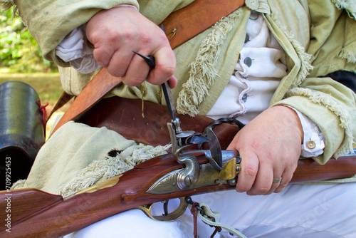 A close up view of a flintlock musket being loaded and prepared before an American Revolution battle reenactment.  photo