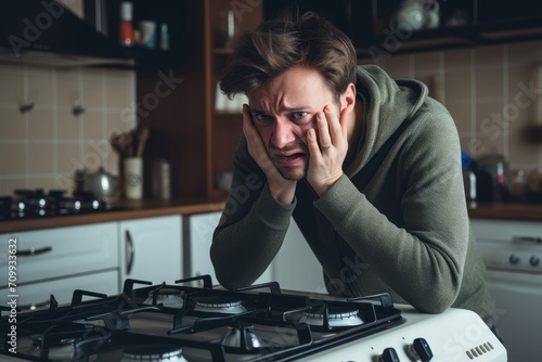 a man looks in horror at the gas bill and reaches his hand to the burner switch on the gas stove