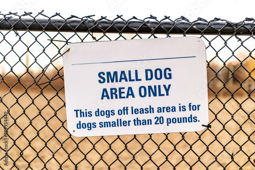 Photography dogwalking: small dog area only dogpark signage on chainlink fence with blurred