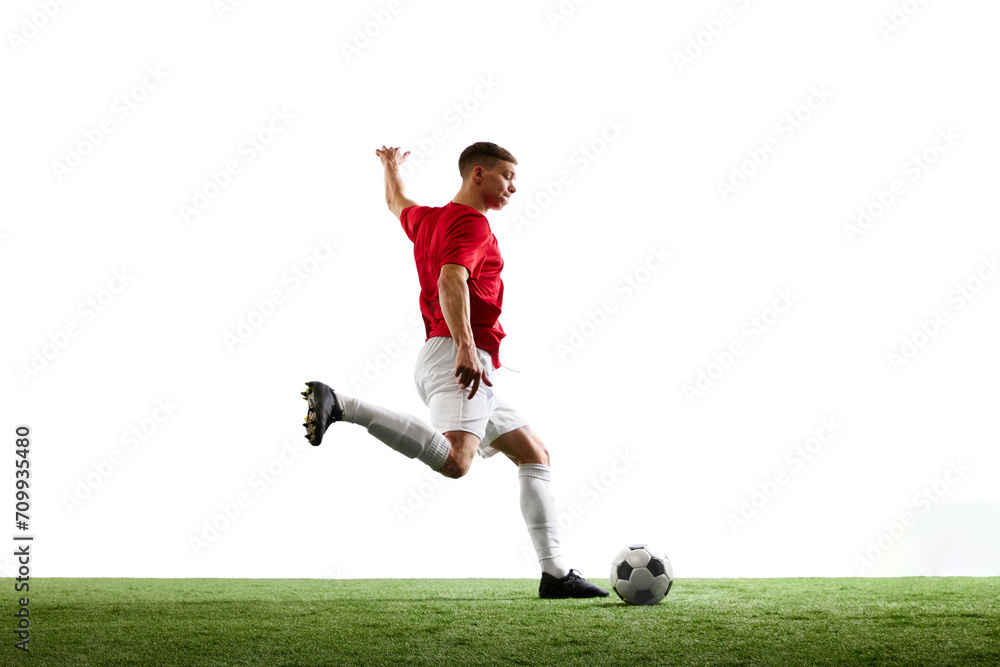 Triumphant kick towards victory. Professional football player sends ball into goal against white background. Concept of sport games, hobby, energy, world cup season, match, movement. Ad