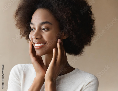 Skincare. Woman with beautiful face touching healthy facial skin. Fascinating portrait of confident girl model with natural makeup enjoys glowing hydrated skin on beige background closeup. High © yahan balch