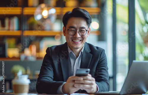 Businessman using mobile phone to search or social media, Business man smiling using smartphone on table