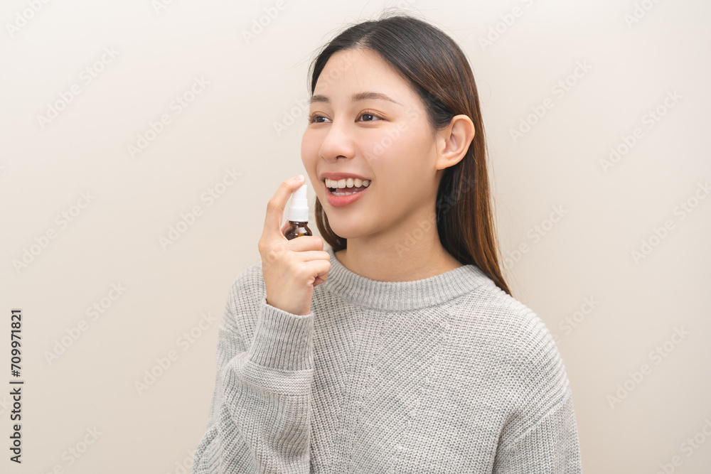 Health care treatment sore throat concept, sick pain asian young woman have cough symptom holding medicine bottle, using spray in mouth to protect disease from bacteria, illness from virus infection. Health care treatment sore throat concept, sick pain asian young woman have cough symptom holding medicine bottle, using spray in mouth to protect disease from bacteria, illness from virus infection.