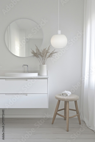 A light-filled minimalist bathroom showcasing a round mirror, pendant lighting, and clean lines, exuding a calm and clean atmosphere.