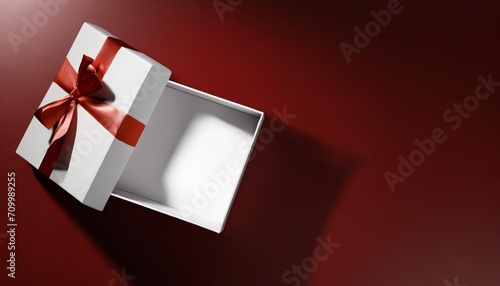 blank white gift box open or top view of white present box tied with red ribbon bow on dark red background with shadow minimal conceptual 3d rendering