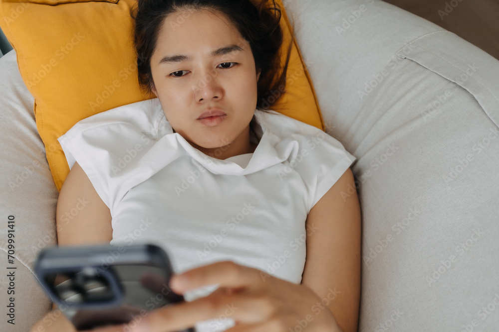Sad and depressed Asian woman using mobile phone looking at the social media and get mental illness. Sad and depressed Asian woman using mobile phone looking at the social media and get mental illness.