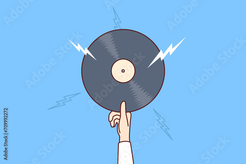Vinyl record with retro music in hand of man offering to listen to classical composition or jazz concert from last century. Vinyl record for meloman enjoys collecting rare audio records