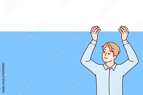 Business man raises blank banner above head and looks up with smile, recommending that pay attention to offer. Promoter guy with copy space for advertising your company or marketing proposal