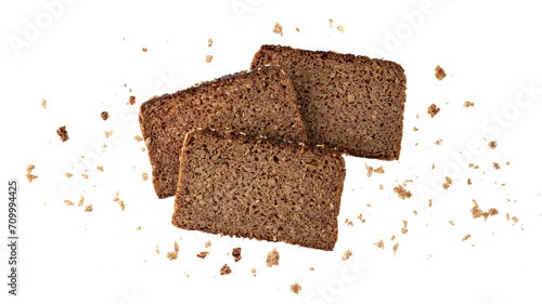 Foto Cutting slices of dark rye cereal bread with crumbs flying isolated on white background