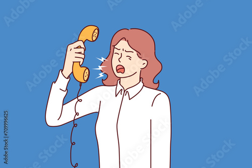 Aggressive woman secretary screams into telephone, arguing with clients or partners because of violation of agreements. Aggressive businesswoman getting angry at interlocutor during negotiations