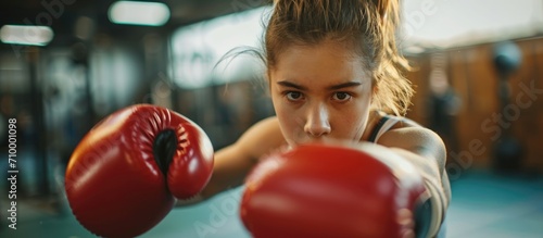 Female youth practicing boxing at the gym. © AkuAku