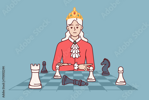 Woman monarch plays chess to develop strategic thinking and awaits opponent move with haughty look. Beautiful queen sits near chess board, wanting to beat opponent in sports tournament