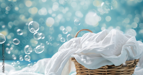 Basket of clean laundry and soap bubbles on blue background. Spring cleaning concept, banner with copy space for cleaning service. photo