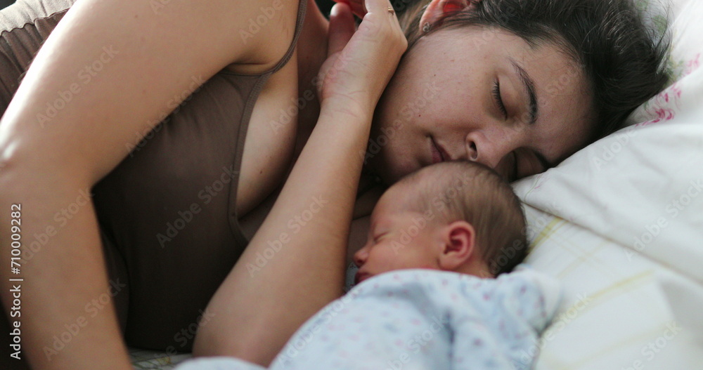 Candid mother and newborn baby sleeping in bed together, real life family moment Candid mother and newborn baby sleeping in bed together, real life family moment