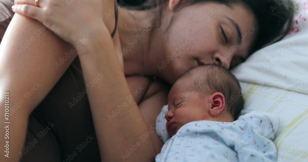 Newborn baby and mother sleeping together in bed, candid real life family moment Newborn baby and mother sleeping together in bed, candid real life family moment