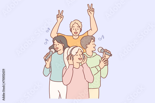 Woman wearing headphones listens to popular music, standing near singing people with microphone