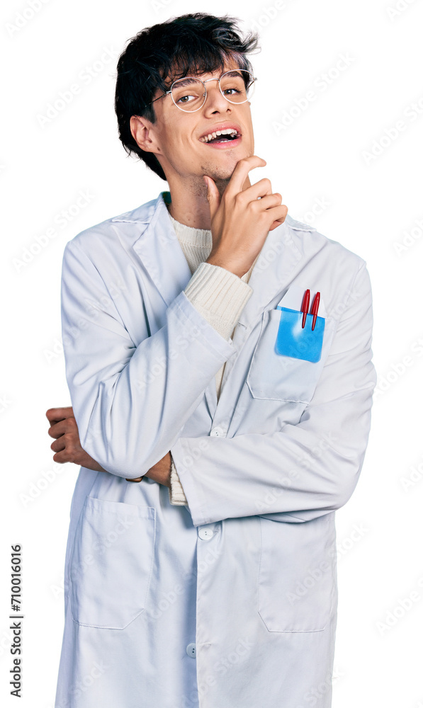 Handsome hipster young man wearing doctor uniform smiling looking confident at the camera with crossed arms and hand on chin. thinking positive.