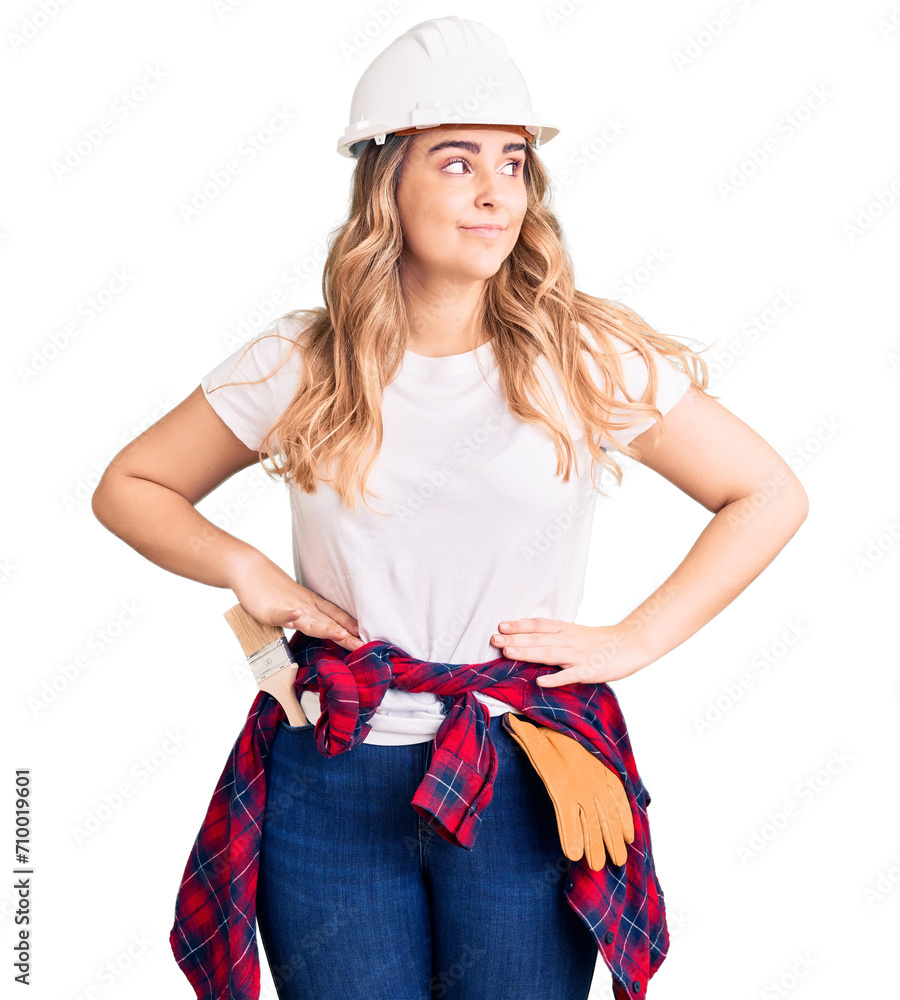 Young caucasian woman wearing security helmet smiling looking to the side and staring away thinking. Young caucasian woman wearing security helmet smiling looking to the side and staring away thinking.